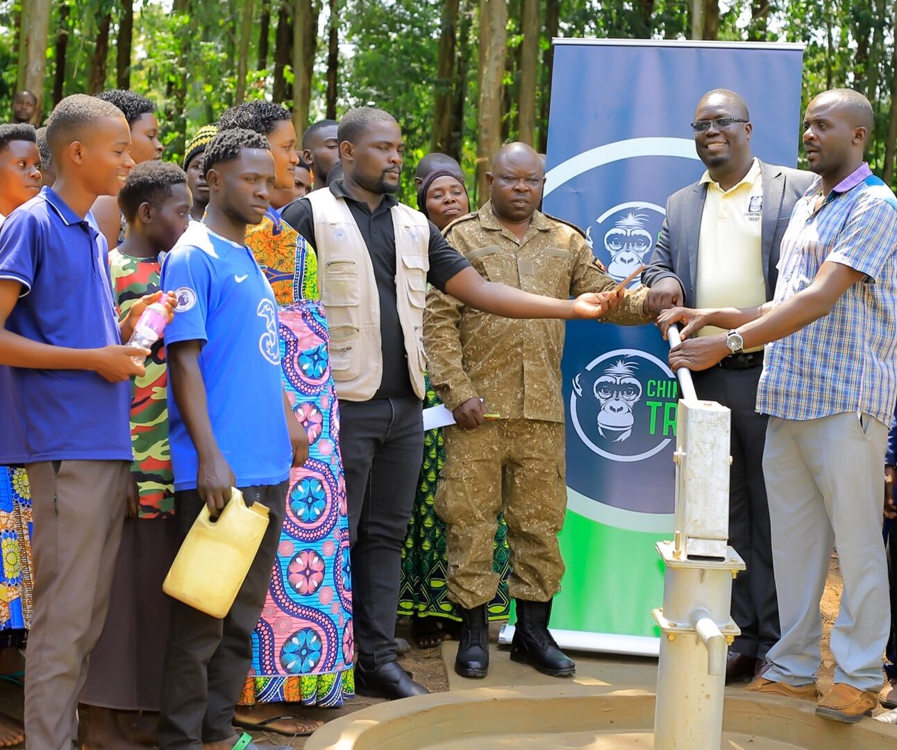 A group of people standing around a newly opened borehole