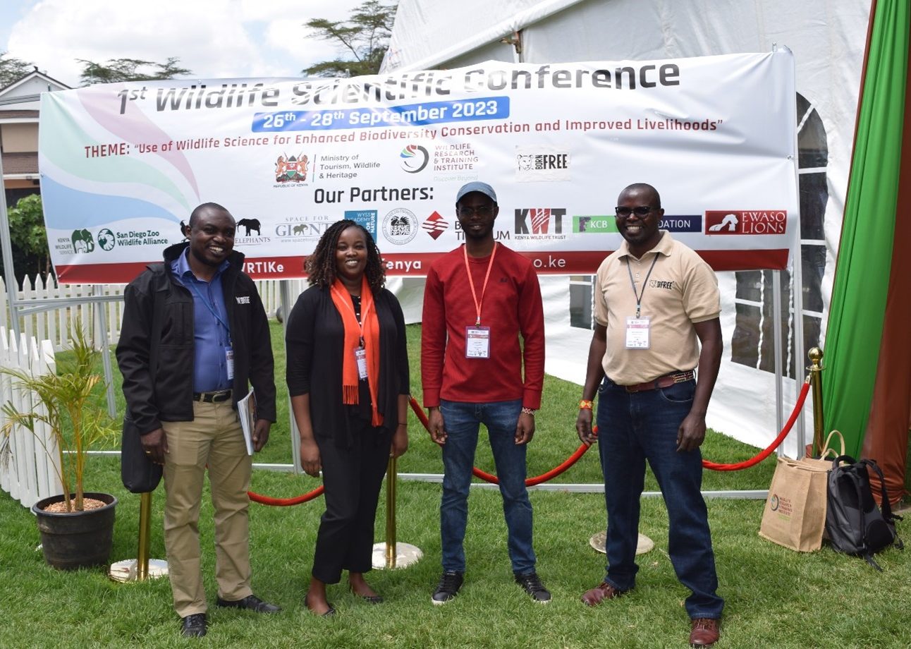 A group of people standing in front of a banner at a conference
