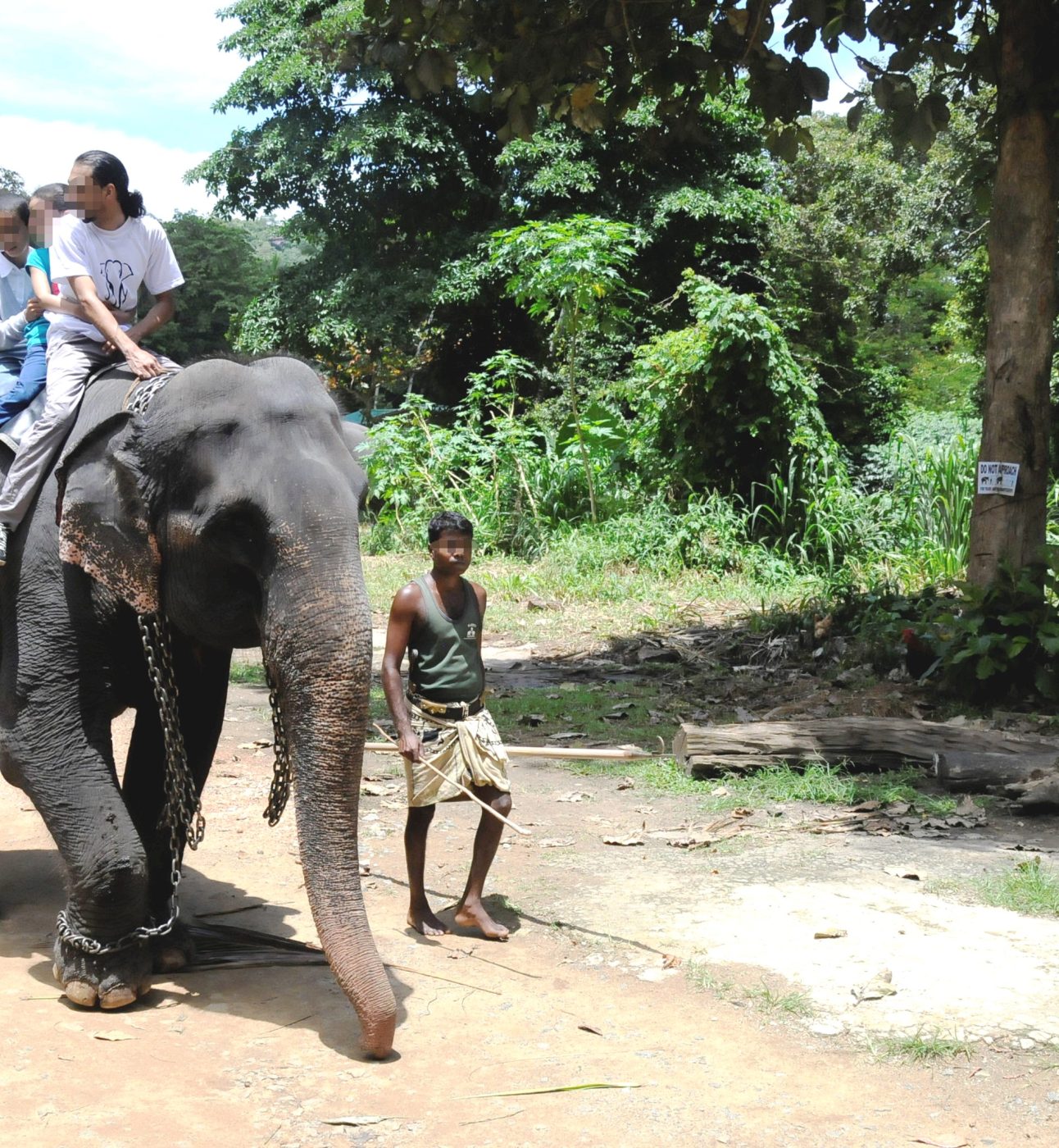 Three people riding an elephant.